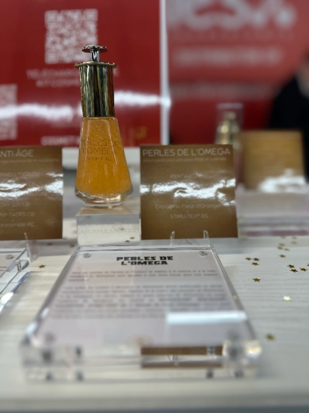Flacon de sérum cosmétique Perles de l'Oméga avec étiquette produit sur présentoir transparent