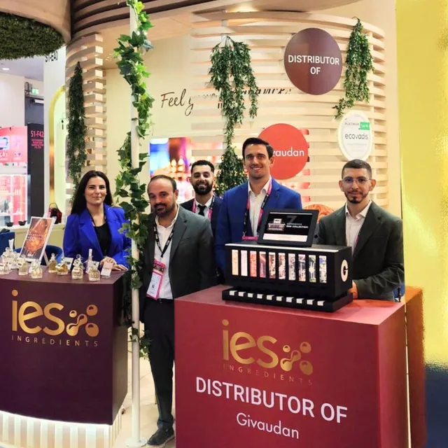 Équipe IES Ingredients sur leur stand salon professionnel avec produits cosmétiques naturels exposés
