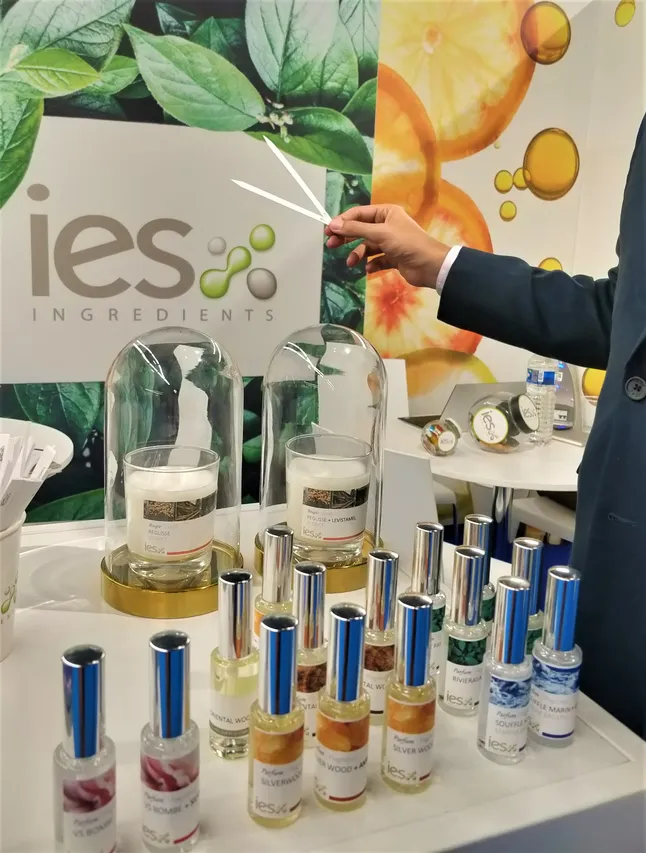 Stand IES Ingredients avec présentoir de flacons d'arômes et parfums naturels lors d'un salon professionnel