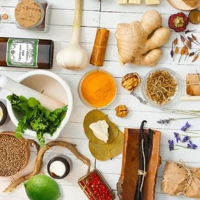 Ingrédients naturels variés pour cosmétiques et parfums : épices, plantes, huiles essentielles sur fond blanc