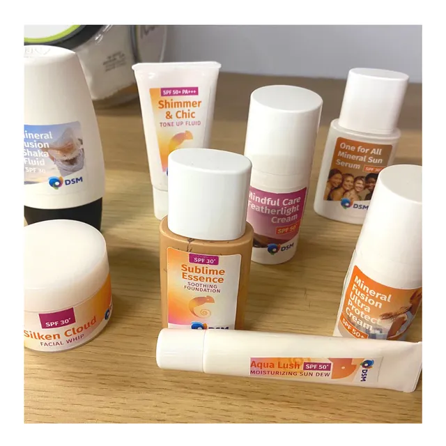 Collection of DSM cosmetics and sun care products with SPF, creams and lotions on wooden table