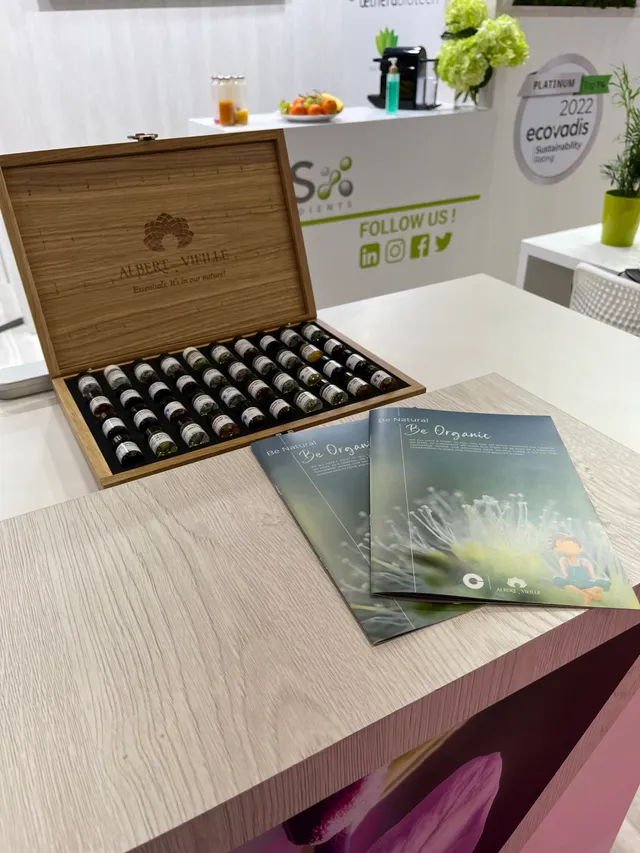 Coffret en bois ouvert contenant des flacons d'huiles essentielles avec brochures Be Organic sur table