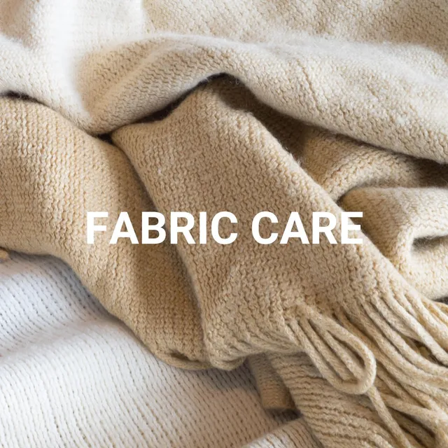 Soft beige wool blanket folded with FABRIC CARE text - natural textile care